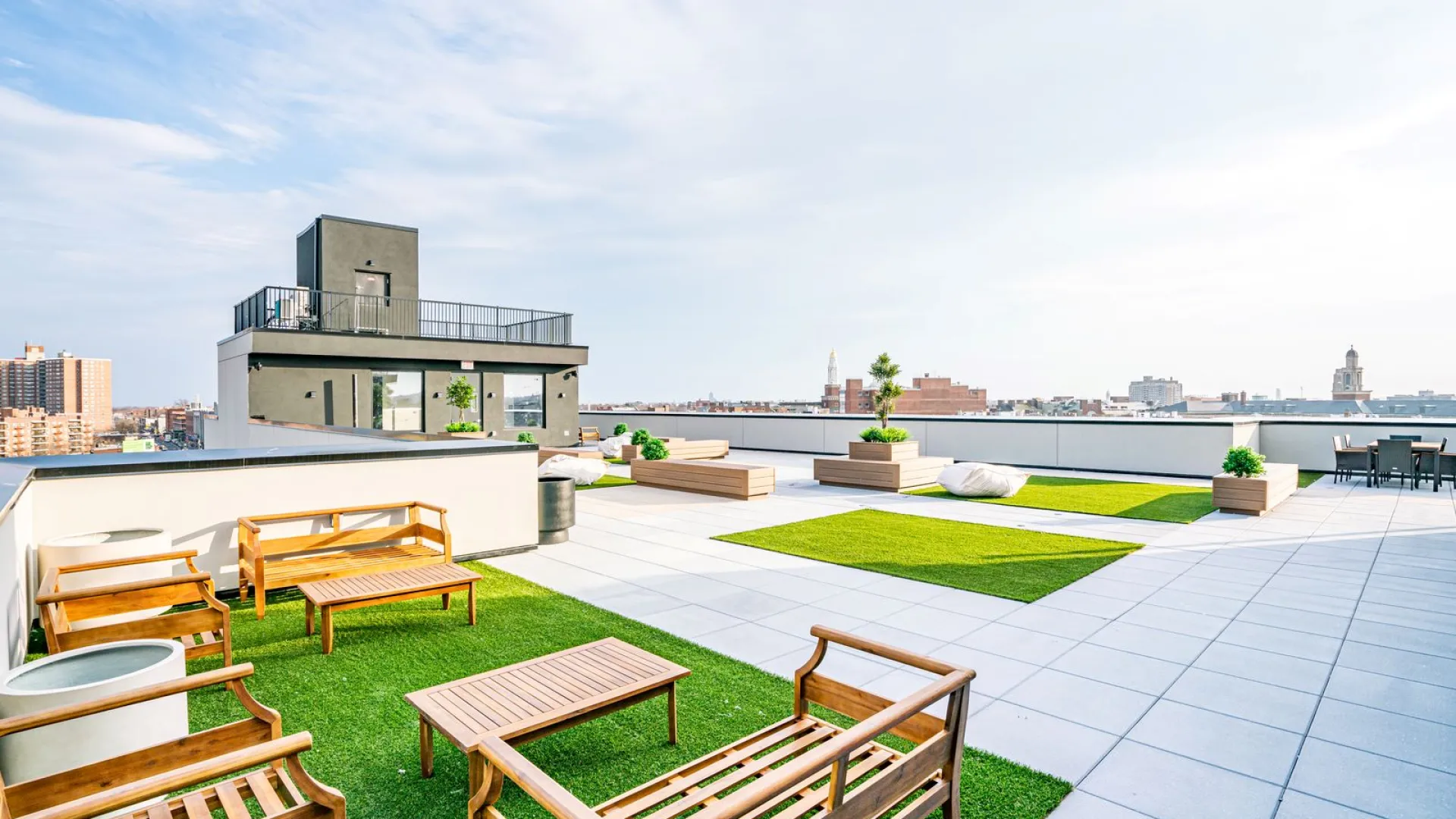 a patio with benches and a body of water in the background