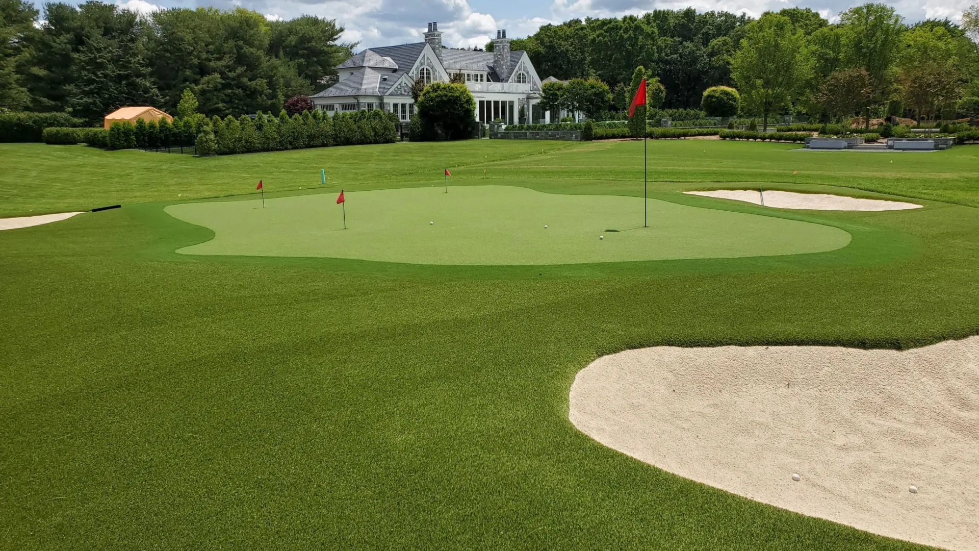 a golf course with a large house in the background