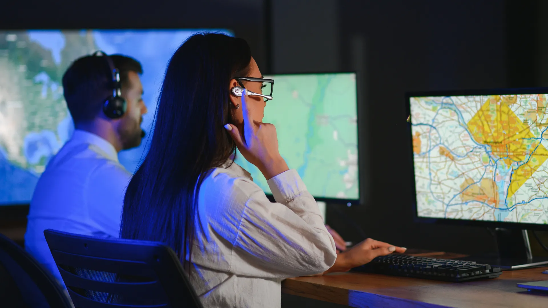 a person wearing headphones and sitting at a desk with a computer