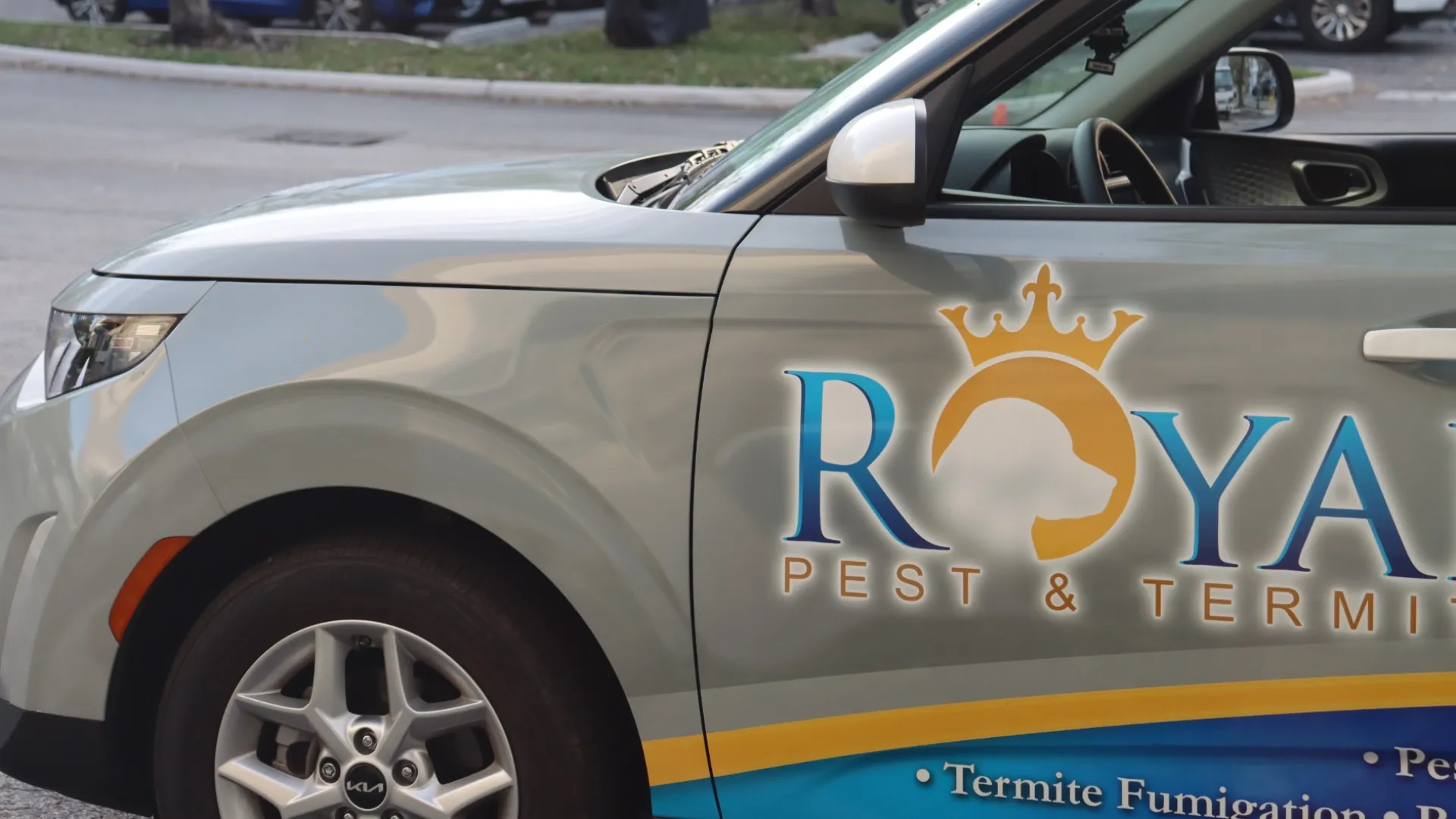 Silver car with Royal Pest & Termite logo and termite fumigation advertisement on the door.