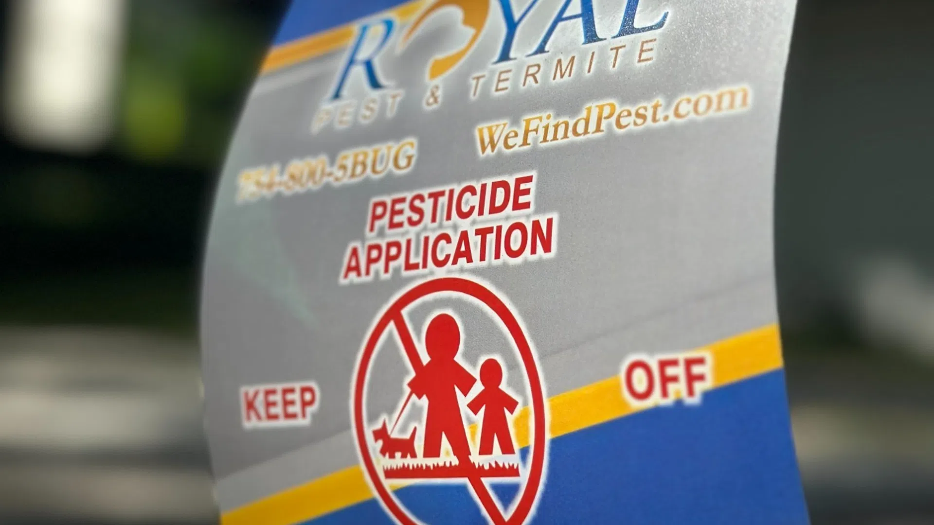 Sign warning of pesticide application with Royal Pest & Termite branding and contact details.