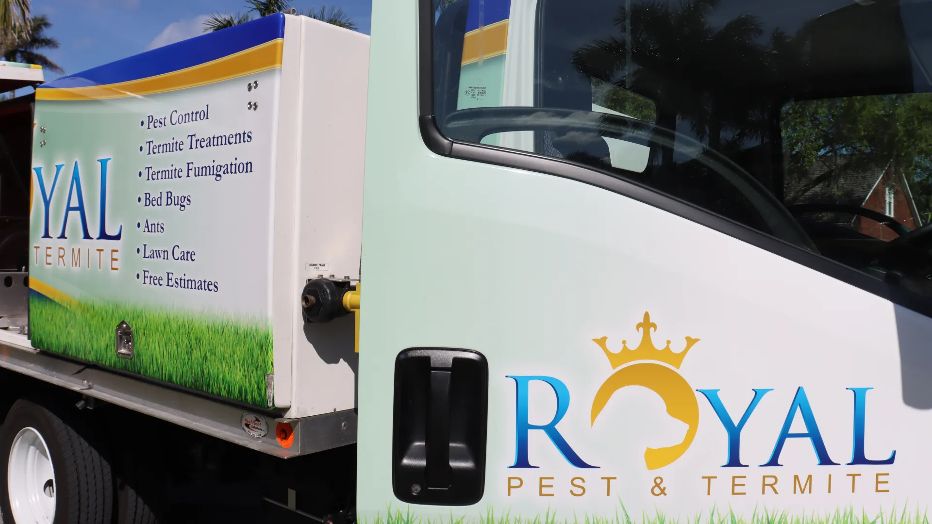 Royal Pest & Termite service truck with logo and list of pest control services parked outdoors under blue sky.
