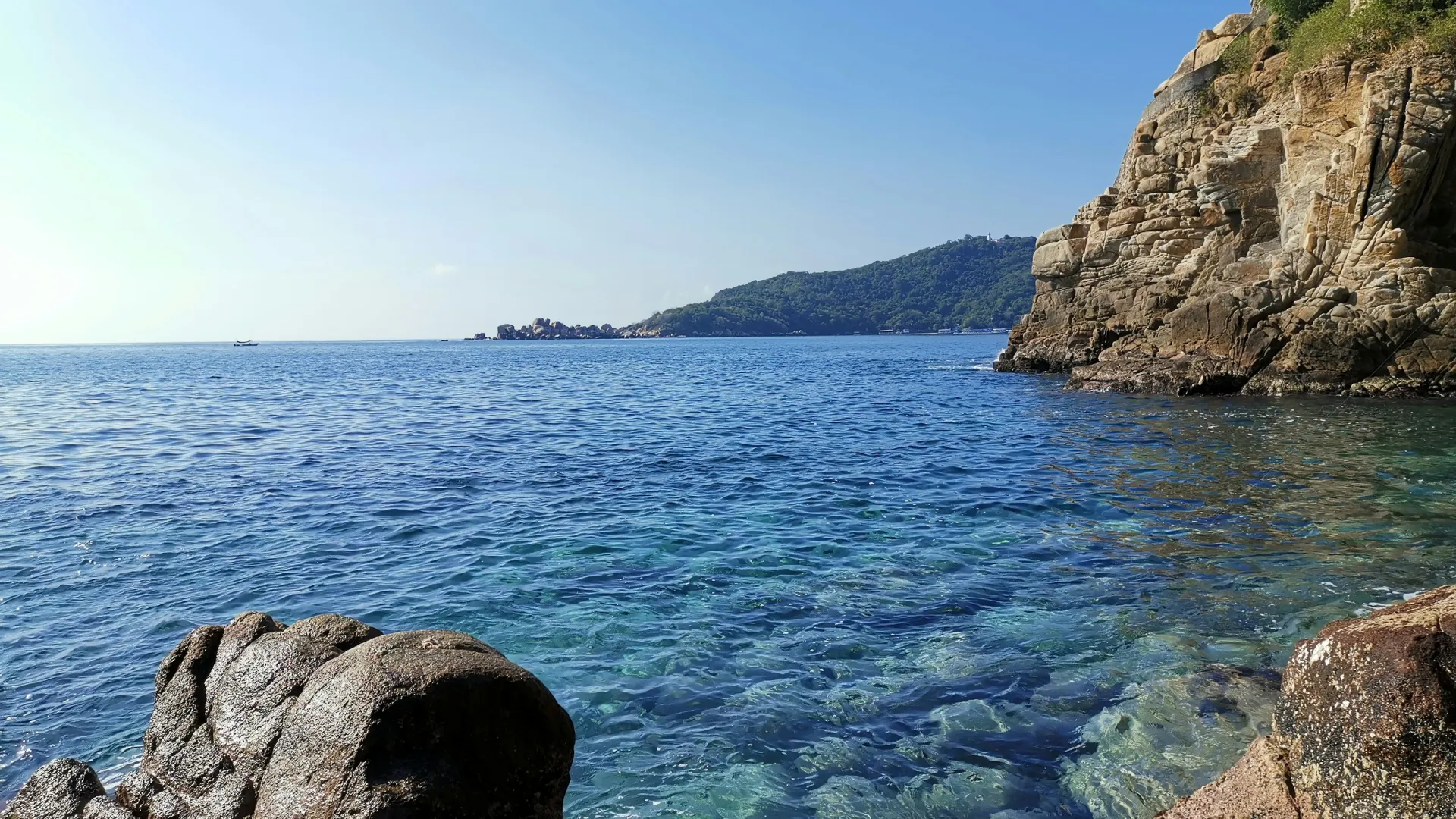 a rocky beach with a body of water in the background