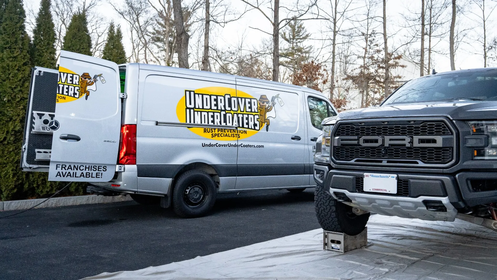 A Ford truck showcased next to an Undercover Installers van in a residential setting, highlighting vehicle services.