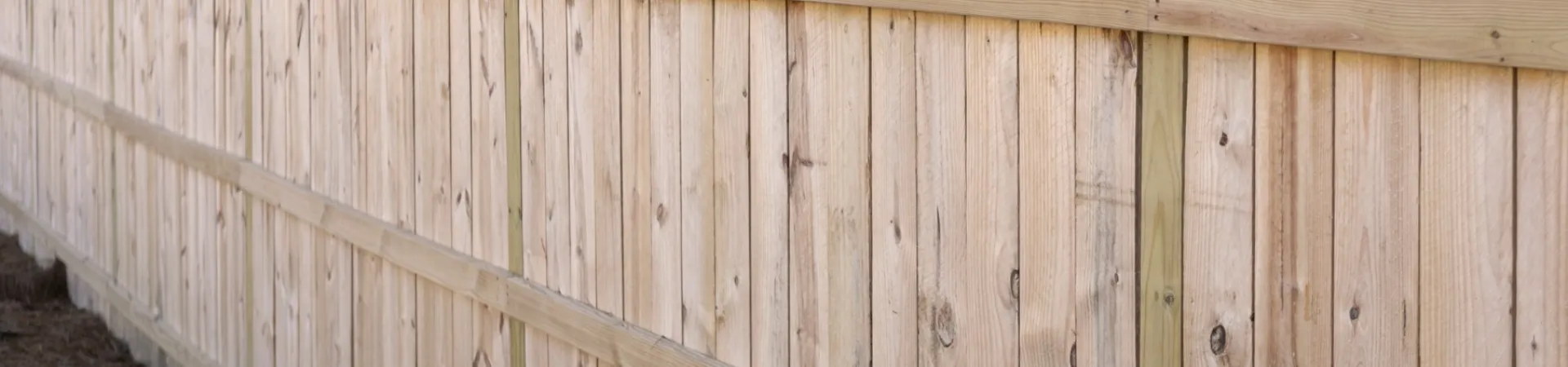 a wooden fence with trees in the background