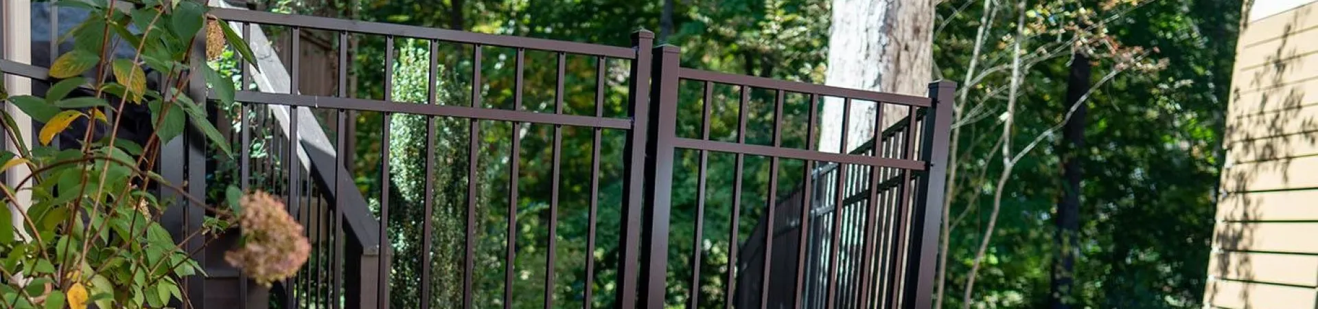 a gated yard with a metal gate and a brick wall