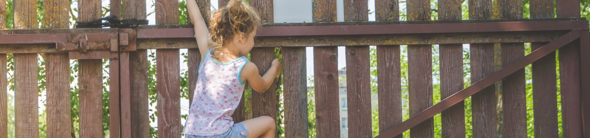 a girl climbing a fence