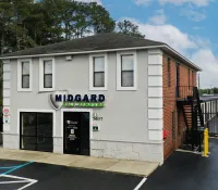 a white building with a black gate with 251 Menlove Avenue in the background