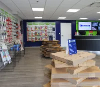Interior of a storage supply store showing moving boxes, locks, packing supplies, and a customer service desk.
