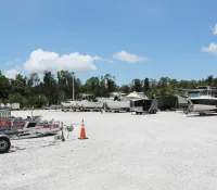 a group of trailers parked in a sandy area with trees in the background