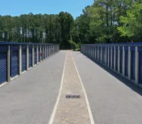 a row of blue metal fenced off area with trees in the background