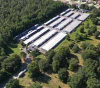 a large building with many windows surrounded by trees