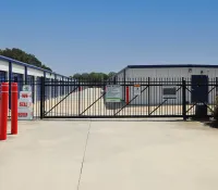 a gated off area with a sign and a building in the background