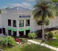 a building with palm trees and a lawn