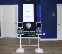 Midgard Storage digital kiosk with live help tablets in a room with blue walls and wooden floor.