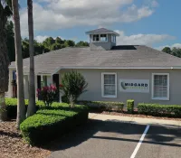 a building with palm trees and bushes