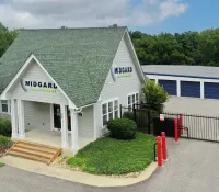 a white building with a green lawn