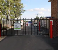 a black gate with red and white signs on it