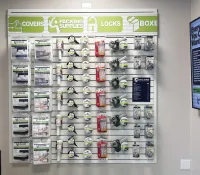 Retail wall display of covers, packing supplies, locks, and boxes organized by type and brand.