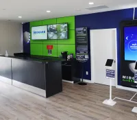 Modern self-storage office interior with sleek black counter, digital screens, and customer service kiosks.
