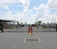 a parking lot with a fence and a building in the background