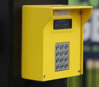 a yellow telephone on a pole