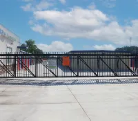 a black gate with a building in the background