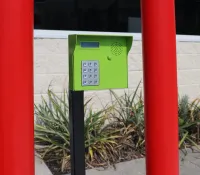 a green and white box on a red pole