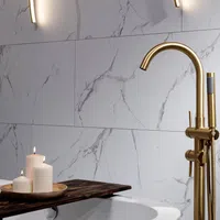 Modern bathroom with gold faucet, marble wall tiles, wooden tray, and lit white candles for a cozy ambiance