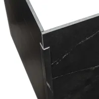 Close-up of a black marble corner with metal edge trim showcasing texture and craftsmanship.