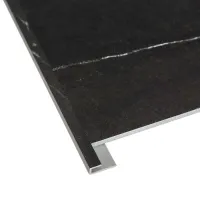 Close-up of black stone tile with metal edge trim on white background highlighting material and finish