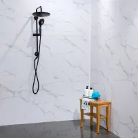 Modern black showerhead and handheld shower mounted on white marble tiled wall with wooden stool and bath accessories.