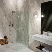 Modern bathroom with marble walls, walk-in glass shower, floating sink, and wooden accents including stool and shelf.
