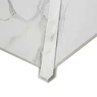 Close-up of white marble tiles with gray veining laid at a corner edge with a narrow marble strip.