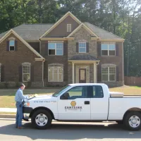 a person standing next to a white truck in front of a house