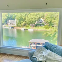 a room with a table and chairs and a body of water
