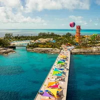 Aerial view of a colorful pier leading to a tropical island water park with blue ocean and clear skies at perfect day at cococay.