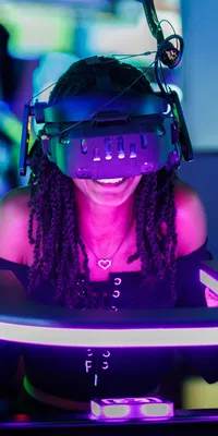 Young woman enjoying immersive virtual reality experience with headset in neon-lit arcade or gaming zone.