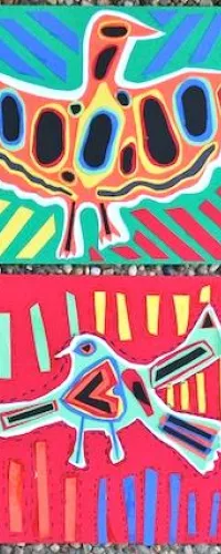 Four colorful abstract bird paintings with geometric patterns on vibrant backgrounds laid on gravel.