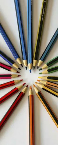 Colored pencils arranged radially with tips forming a heart shape on a white background.
