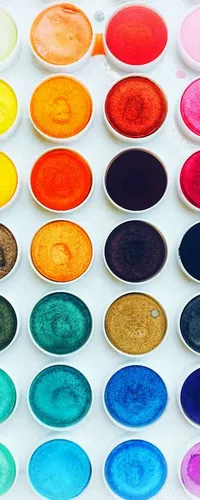 Top-down view of a watercolor paint palette with 24 vibrant colors arranged in a grid on a white tray.