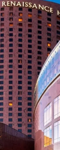 Renaissance hotel tower with illuminated windows during dusk and reflective glass facade in foreground