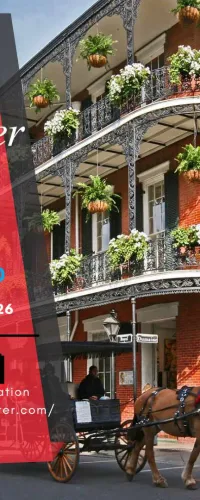 Historic New Orleans building with ornate iron balconies and hanging plants next to a horse-drawn carriage on street.