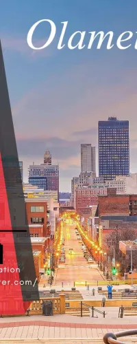 City skyline at sunset with promotional banner for MEA Energy Association booth at Olameter event May 12-14, 2026.