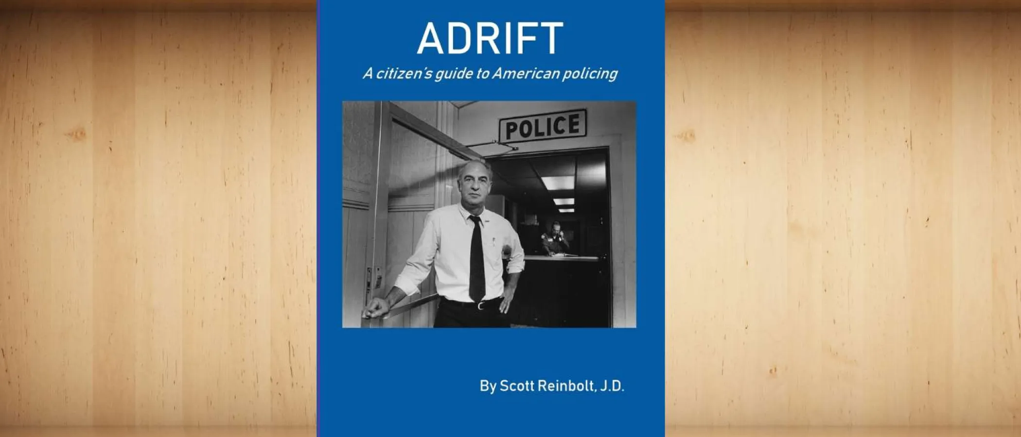 Book cover for Adrift, a citizen's guide to American policing by Scott Reinbolt with a black and white police station photo.