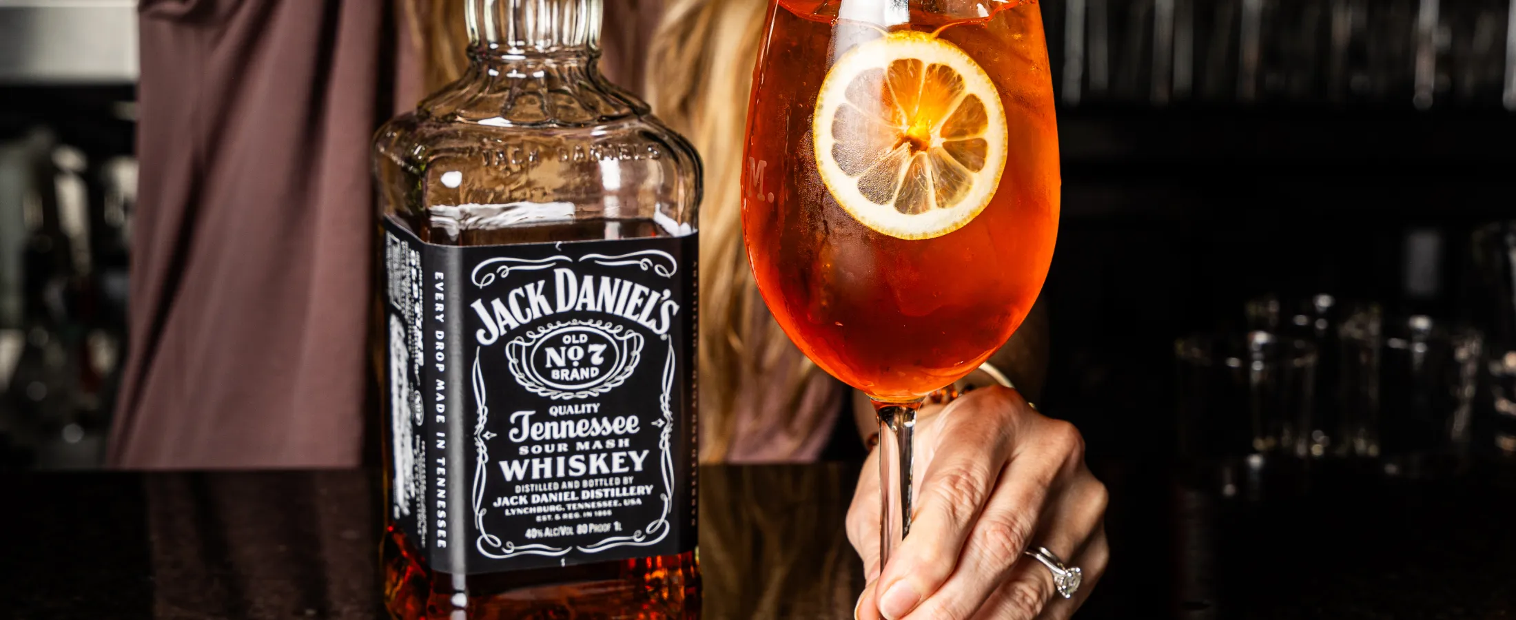 a bottle of alcohol next to a glass with a drink in it