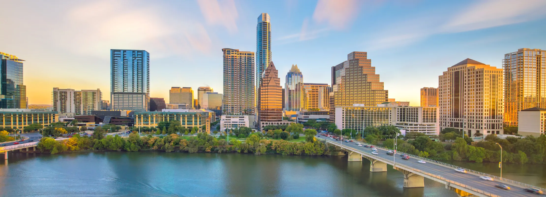 Aerial view of Houston skyline with lush green parks and blue skies in the background.