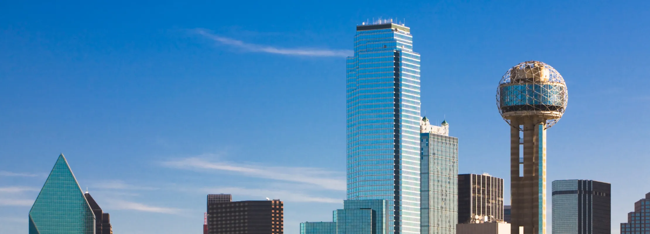 Dallas skyline featuring distinctive architectural landmarks and clear blue sky.
