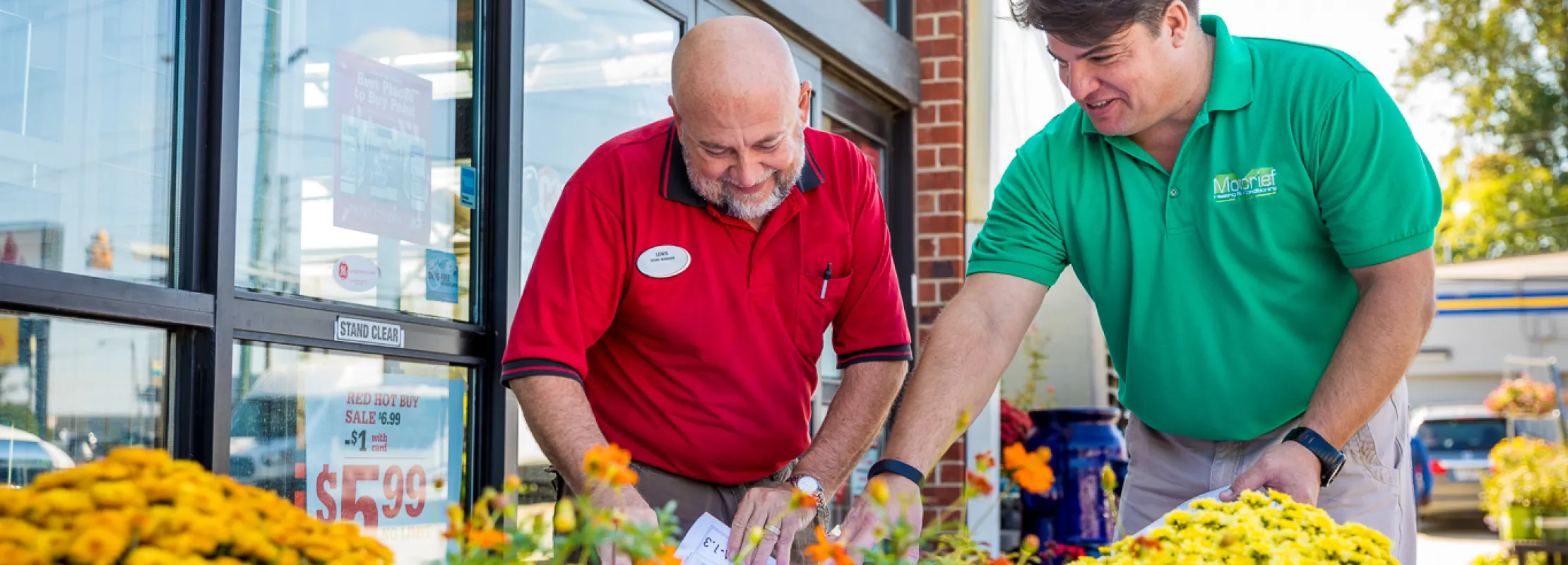 a couple of men looking at flowers