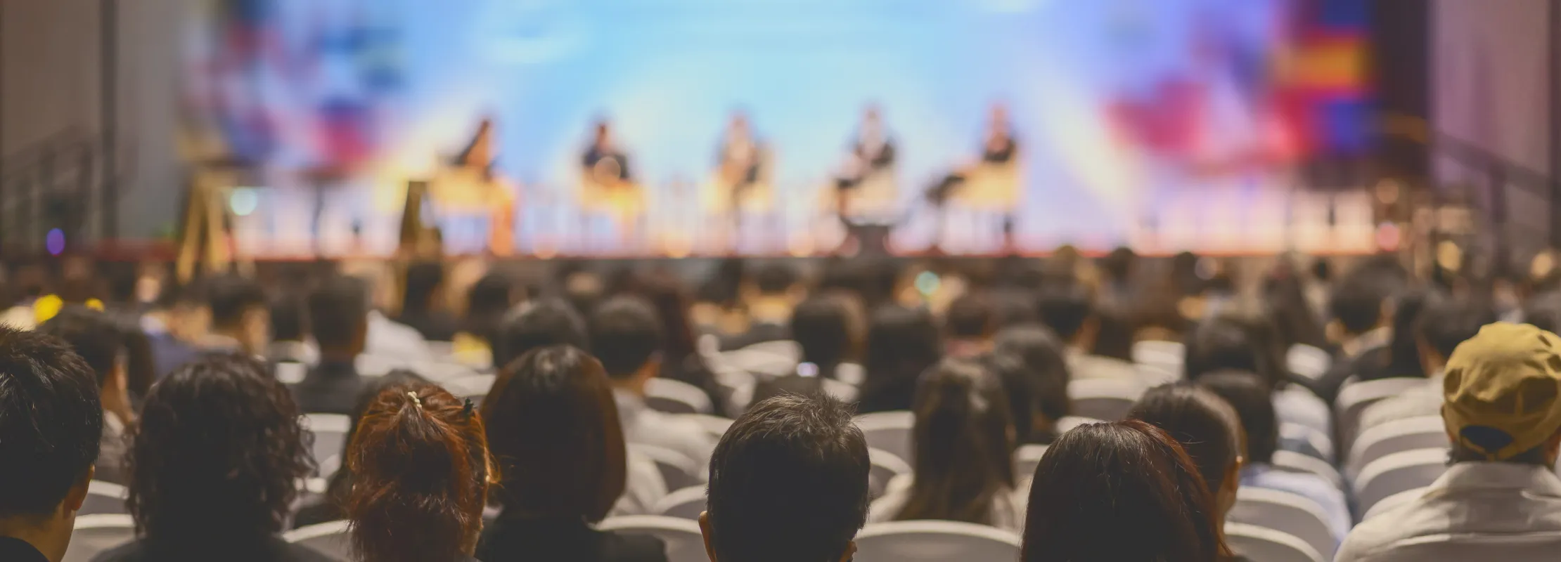 a group of people sitting in a room watching a presentation